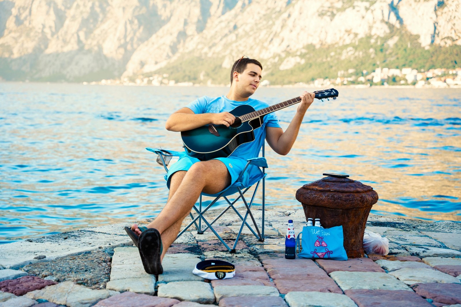 Foldable travel guitar being played outdoors by a traveler, highlighting portability and convenience for musicians on the go