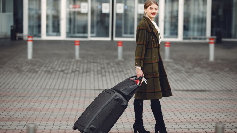Durable modern roller travel suitcase with 360-degree spinner wheels at airport terminal