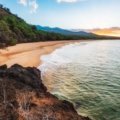 Beautiful Maui tropical beach at sunset with calm ocean waves and lush green landscape