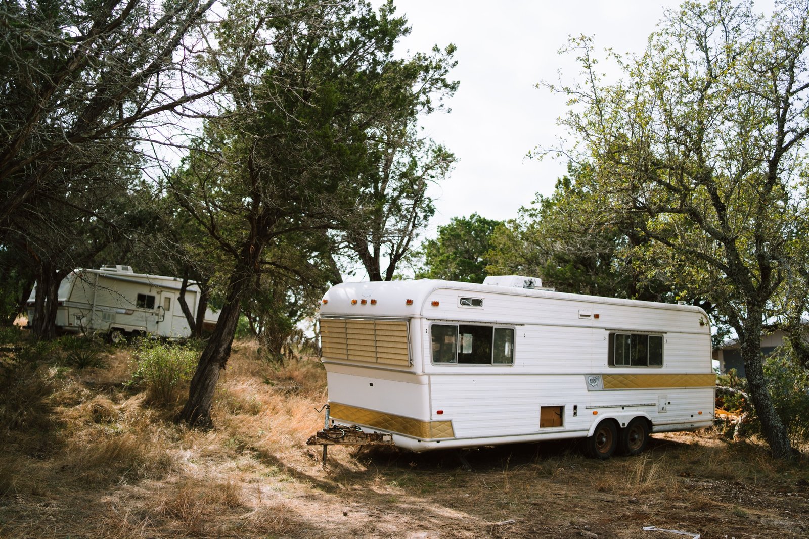 Parked travel trailer secured with stabilizer jacks and wheel chocks during windy weather for safety