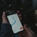 Business employee using GPS tracking on smartphone for travel safety and location monitoring