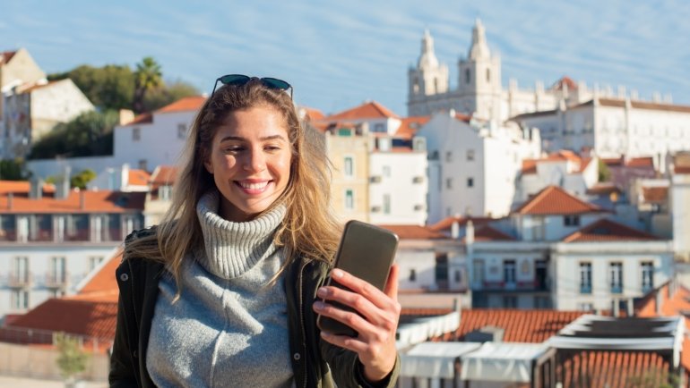 Traveler using discount code on smartphone during half day city tour saving money