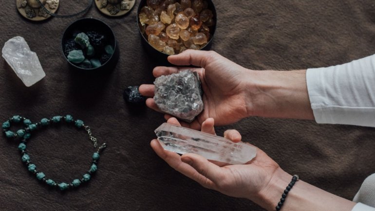 Travel protection crystals including amethyst and black tourmaline next to a suitcase symbolizing spiritual safety and calm during journeys