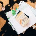 Person planning a trip with an Albania travel guide book and map showing destinations and cultural sites