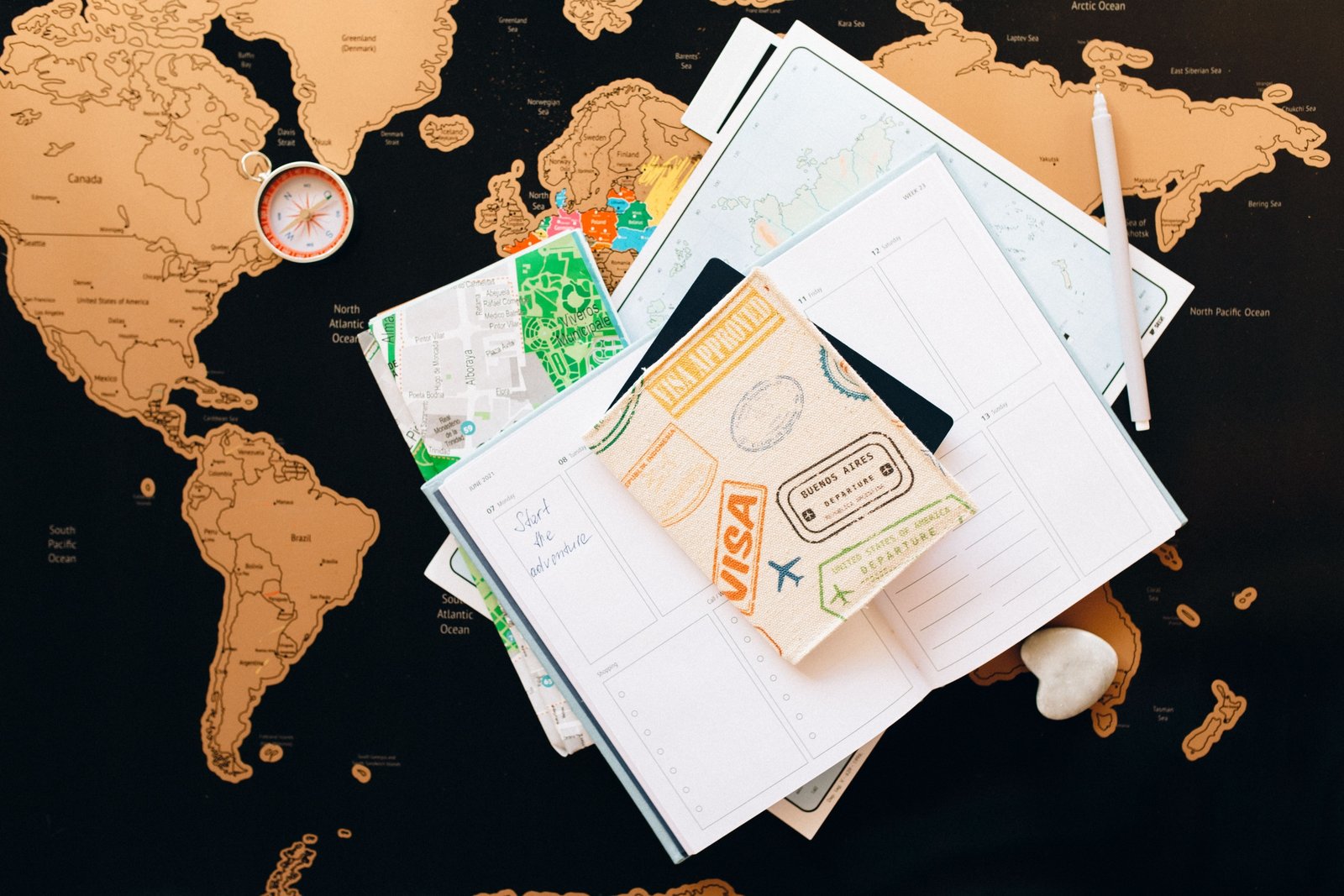 Person planning a trip with an Albania travel guide book and map showing destinations and cultural sites