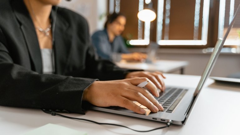 Travel agent using laptop to manage bookings and access travel portal