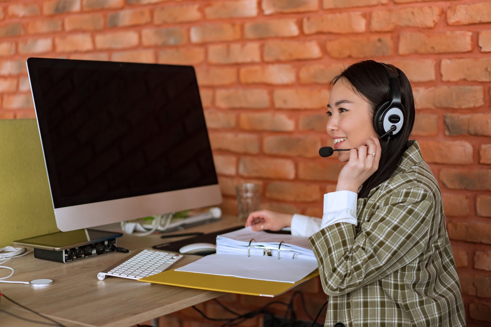 Travel agent working at desk with computer planning and booking trips
