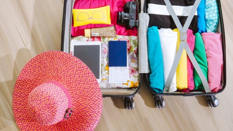 Baseball cap stored safely in a protective travel bag inside an open suitcase, highlighting organized and secure packing for travel