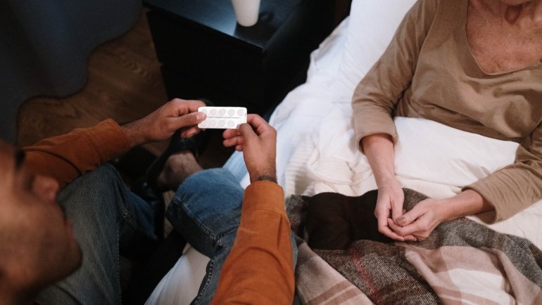 Travel hospice nurse providing compassionate care to elderly patient in a cozy home setting