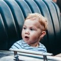 Toddler safely and comfortably seated in a travel car seat inside a family car during a road trip