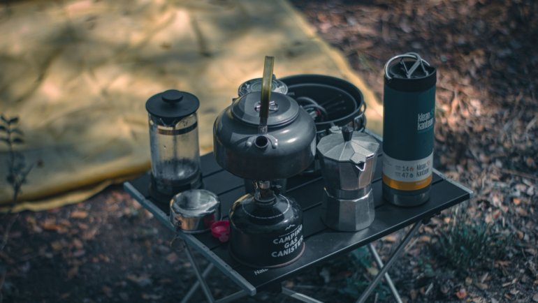 Coffee press travel mug with fresh brewed coffee, perfect for outdoor use and eco-friendly travel
