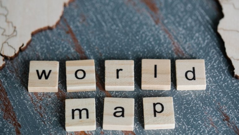 Person learning Spanish travel vocabulary with map and notebook for effective language translation