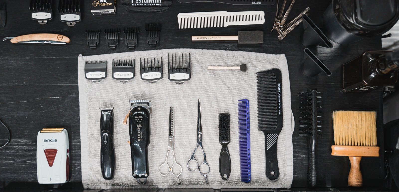 Barber travel bag open with organized grooming tools including scissors, clippers, and combs for professional use
