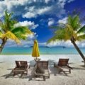 Sunlit tropical beach in Southeast Asia with clear skies and palm trees, perfect travel destination during dry season