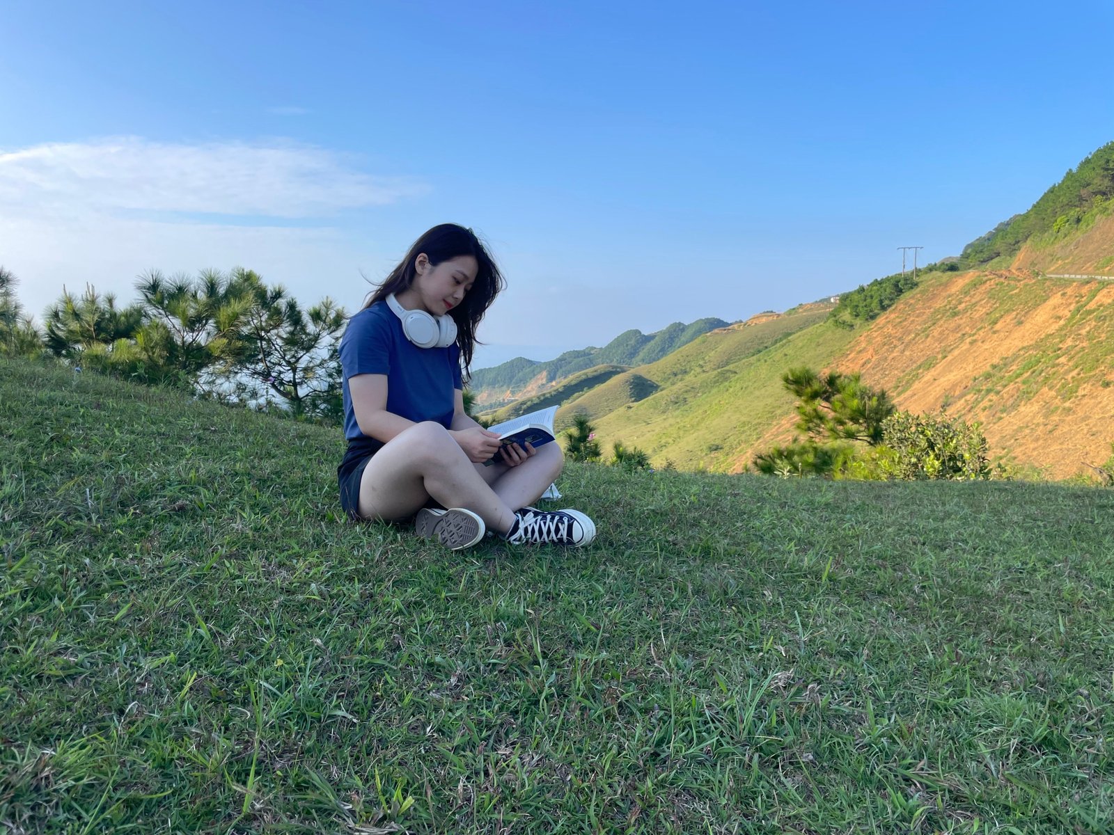 Person reading an adventure travel book outdoors surrounded by nature, inspiring wanderlust and exploration