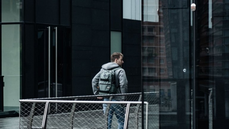 Modern black Nomatic travel backpack on a traveler in the city, featuring durable materials and smart compartments