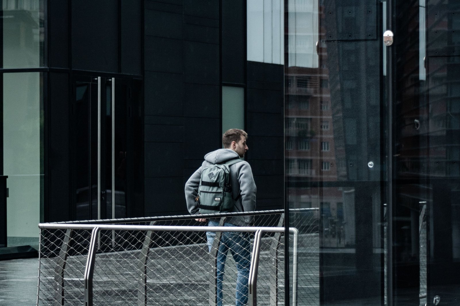 Modern black Nomatic travel backpack on a traveler in the city, featuring durable materials and smart compartments