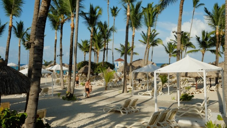 Traveler relaxing on a Dominican Republic beach with travel insurance protection for medical emergencies and trip cancellations