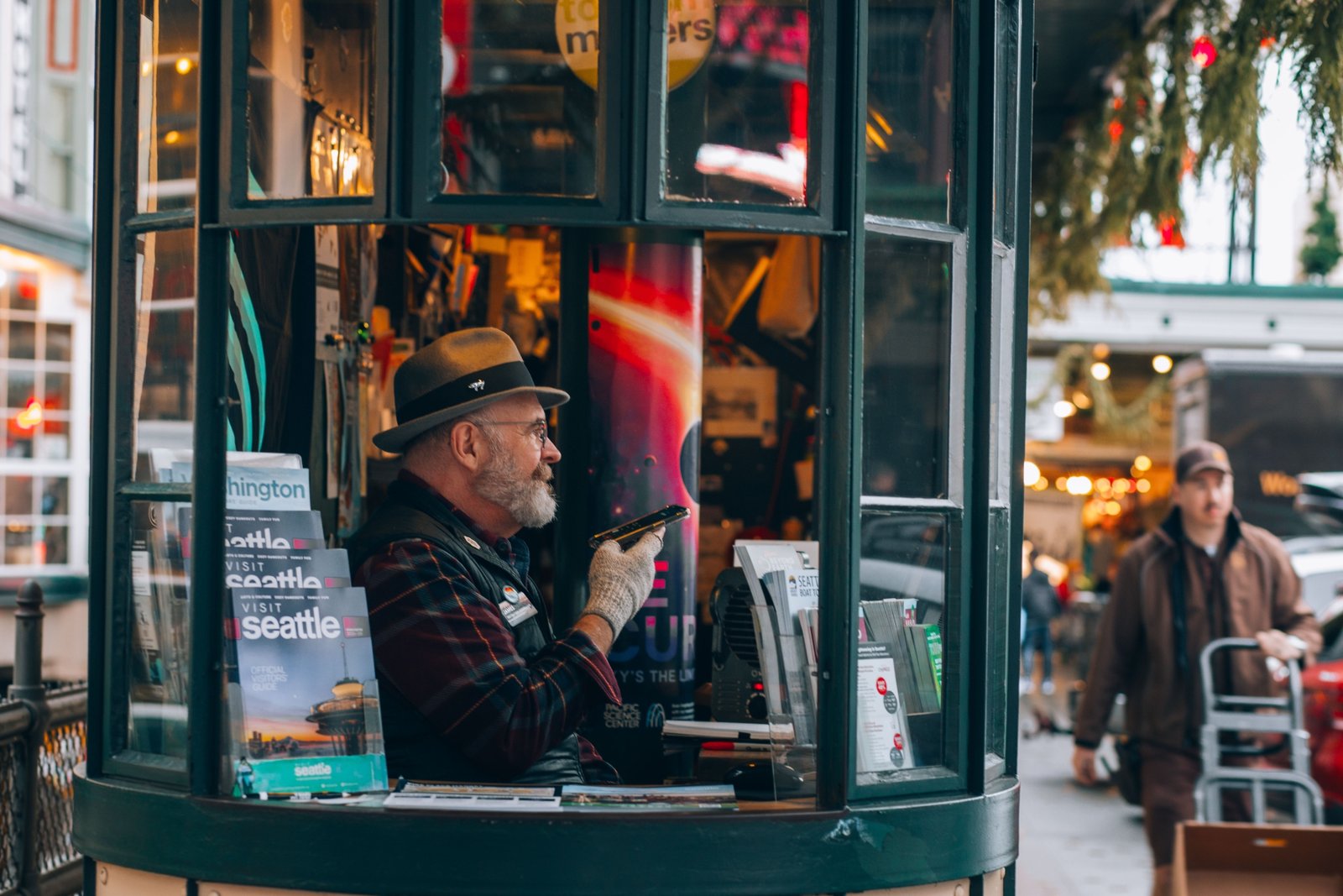 Travel agent consulting client on personalized Seattle travel itinerary with maps and brochures