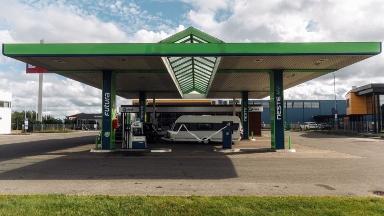 Road trip rest stop with fuel station, convenience store, and parking area for cars, trucks, and RVs