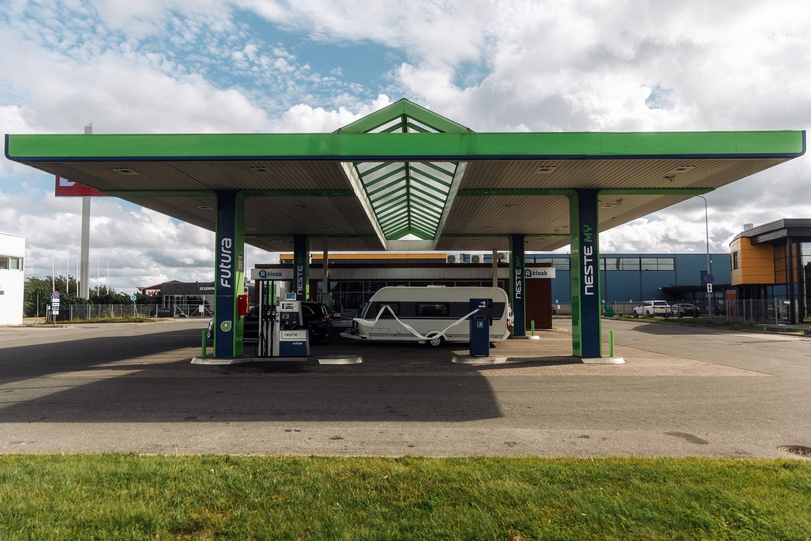 Road trip rest stop with fuel station, convenience store, and parking area for cars, trucks, and RVs