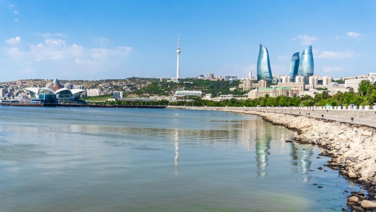 Beautiful scenic landscape of Azerbaijan featuring mountains, Caspian Sea beach, and historic city elements