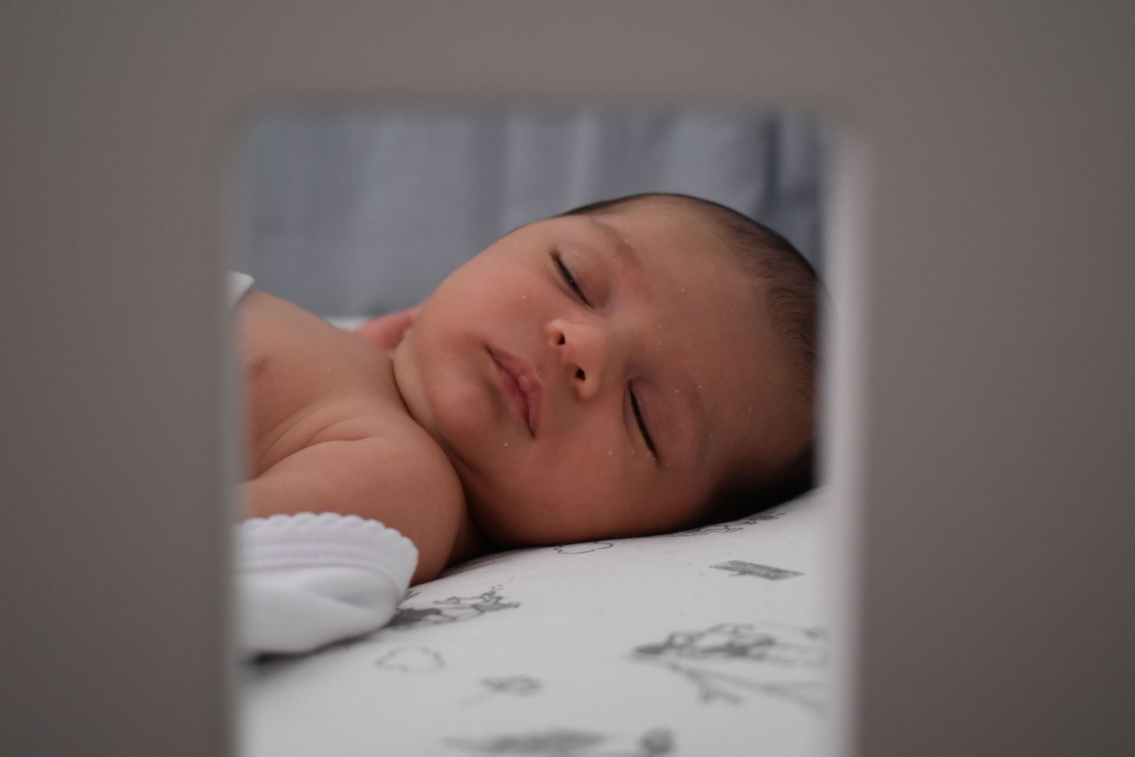 Baby peacefully sleeping on a comfortable and safe travel crib mattress during a family trip