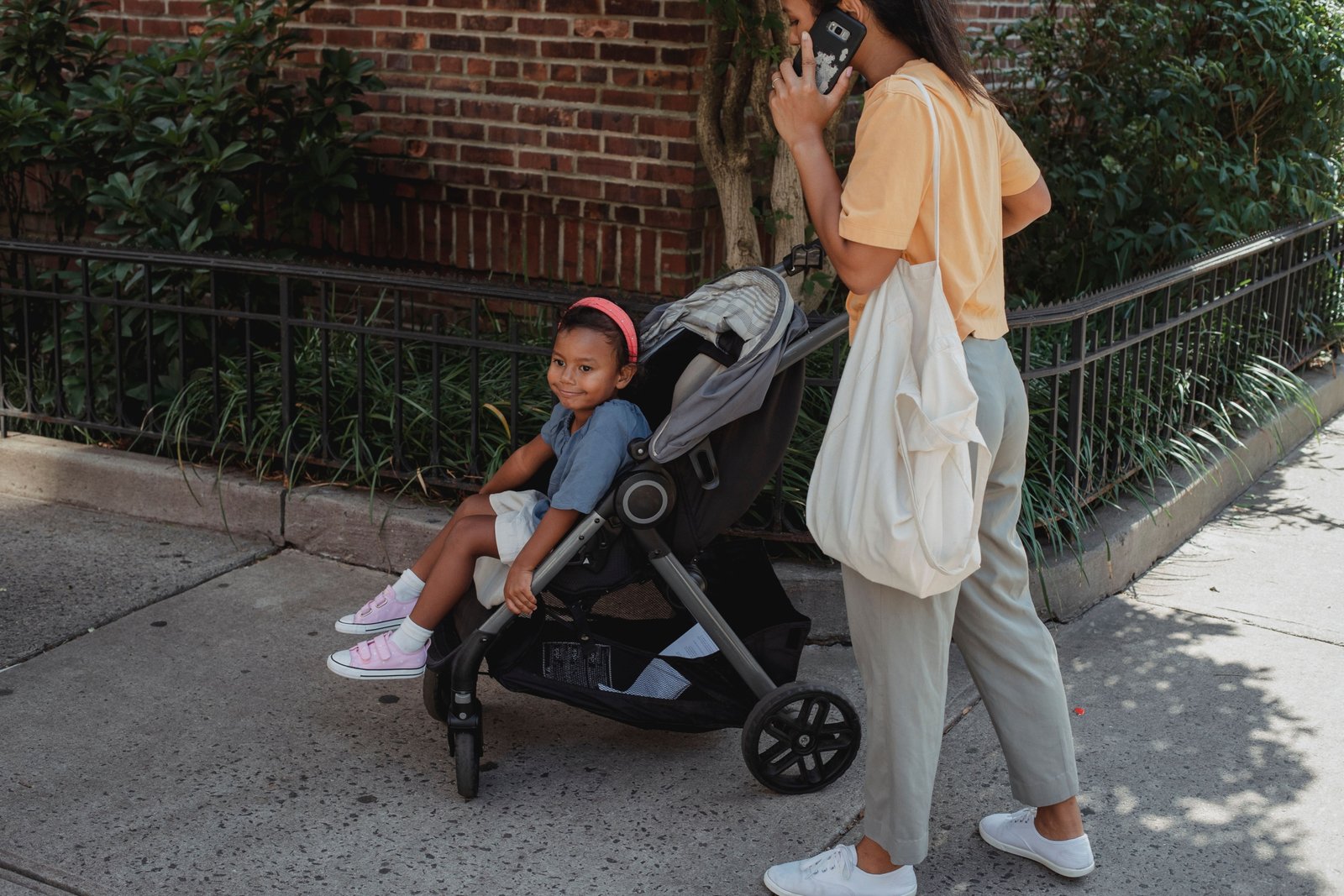 Parent pushing a compact lightweight travel stroller with child facing parent, showcasing bonding and easy maneuverability during travel