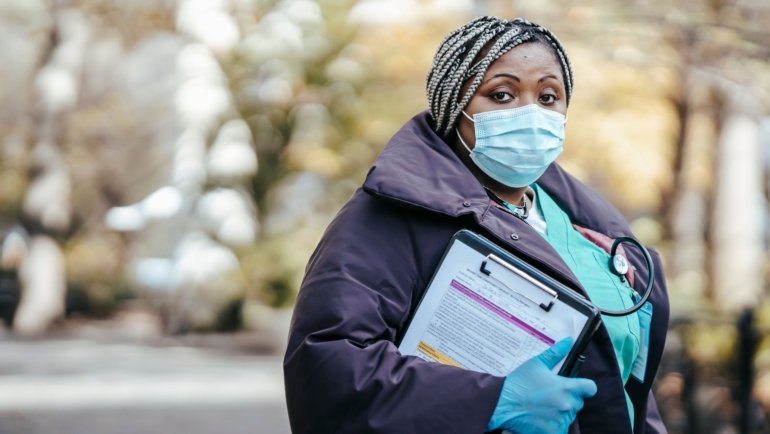 Travel nurse smiling confidently in an urban setting, symbolizing flexible and rewarding travel nursing opportunities