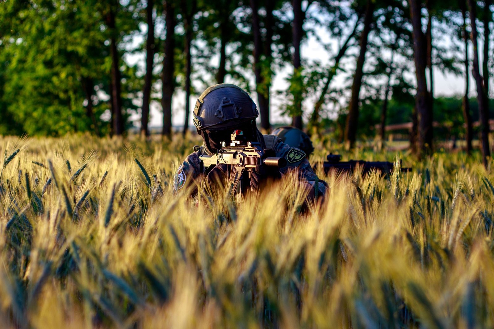 Airsoft player shooting 0.2g BB from gun outdoors with focus on accuracy and range