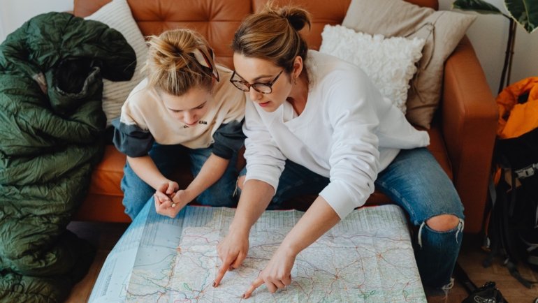 Travel agent helping family plan vacation with maps and brochures, showcasing personalized travel planning in Chattanooga TN