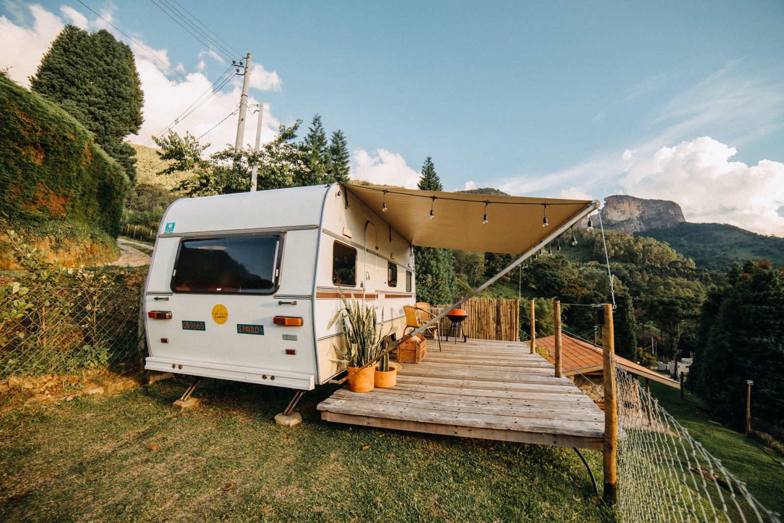 Travel trailer being leveled on uneven terrain at a campsite using leveling equipment for stable and safe setup