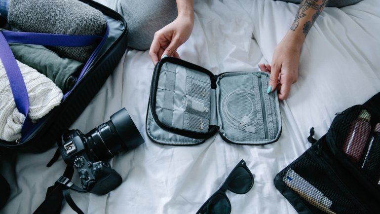 Backpacker organizing essential travel accessories in a well-packed backpack for a comfortable and safe journey
